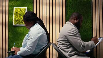 självsäker jobb sökande fyllning i dokument med deras detaljer, Sammanträde i de hall tillbaka till tillbaka innan anställa intervju. granskning cvs och framställning för sysselsättning frågor med hr. kamera a. video