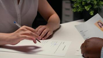 Close up of job seeker signing a work contract after successful interview, applicant reviewing legal terms of employment before signed agreement. Onboarding process for new beginning. Camera B. video