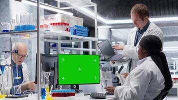 krom nyckel visa på övervaka Nästa till olika experter i kemi labb, använder sig av laboratorium analys för bioteknik och sjukvård teknologi. framsteg i farmaceutisk vetenskap. kamera b. video