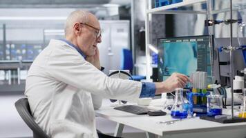 Chemist in biolab observes computer with fascination and curiosity, captivating experiment data results. Intrigued scientist reading unusual biotechnology research discovery. Camera B. video