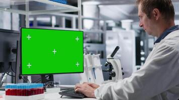 Mockup on desktop next to scientist conducting professional analysis in chemistry lab, experiment data for molecular science. Advanced research, pharmacology and biotechnology discovery. Camera B. video