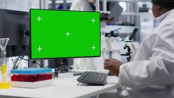 isolerat attrapp skärm Nästa till forskare den där Arbetar för forskning studie, använder sig av labb Utrustning och biokemi verktyg nära skrivbordet st. sjukvård data analys och genetik forskning. kamera b. video