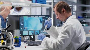 manlig forskare handtag pipett med liten droppe över burk under procedur i de labb. blandning förberedelse stödjande genetik forskning, nanoteknologi och lösningar genom analytisk metoder. kamera b. video