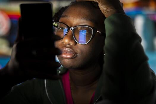 Closeup of bored woman glued to smartphone screen, enjoying leisure time with content on streaming services. Lazy person procrastinating with VOD broadcasts on phone in front of digital backdrop photo