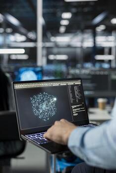Close up of technician in data center using AI LLM assistant on laptop to perform maintenance on hardware rigs. Server farm IT specialist using large language model chatbot on notebook to do backups photo