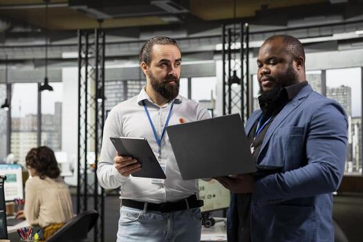 Team of diverse men work with technology and performance metrics, aligning business strategy and project objectives to drive results and success within a multinational company environment. photo