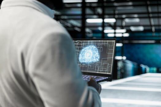 Close up of data center engineer using artificial intelligence on laptop, performing gear maintenance. Server room worker working with AI machine learning, scripting automated workflows photo