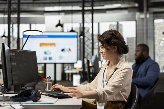 Professional office worker in a modern office monitoring stock trends and candlestick charts on a monitor, using forecasting and finance strategy to optimize trading and achieve revenue goals. photo