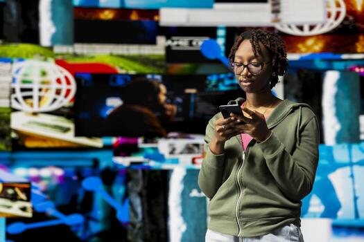 Woman using mobile phone surrounded by curated recommendations while browsing streaming services. African amercian person enjoying free time browsing favorite online clips on smartphone photo