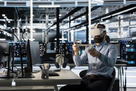 Technician using VR headset in data center to update server tech, configuring equipment using software tools. Server room employee reviewing hardware analytics using virtual reality photo