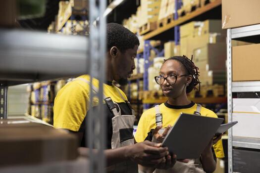 africano americano personal comprobación inventario y envío detalles en ordenador portátil antes de aplicando awb etiquetas grande escala distribución operaciones con estructurado flujo de trabajo y eficiente mercancías seguimiento. foto