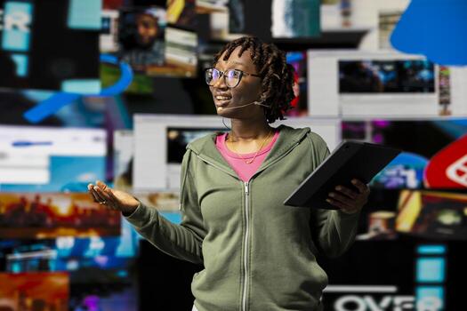 Digital creator doing presentation on social media trends, showing clips on dynamic screen dashboards. Influencer highlighting importance of online engagement and global connection during speech photo