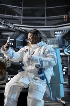Astronaut in starship travelling to space doing selfies using smartphone camera. Cosmonaut aboard orbit station having fun doing photos on mobile phone during cosmic journey