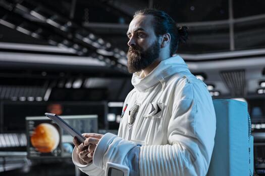 Cosmonaut in orbital station looking at Mars data analysis interface on tablet. Man working on orbital station looking at galaxy visualization, doing Martian surface research to assist planetary exploration photo