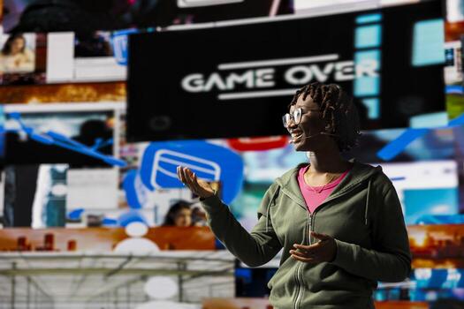 Happy woman doing conference presentation in front of audience, showing clips on digital videowall. Cheerful influencer using mic to talk about content creation and social network experiences photo