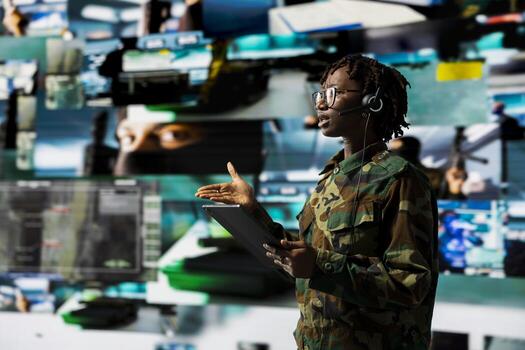 Army telecommunication systems operator using satellite software on tablet, providing combat support. Military dispatcher managing communications networks with digital device photo