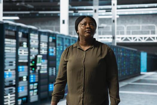 Engineer walking through server farm rows lined with storage infrastructure rigs. IT expert inspecting data center facility helping power online services for enterprise customers photo
