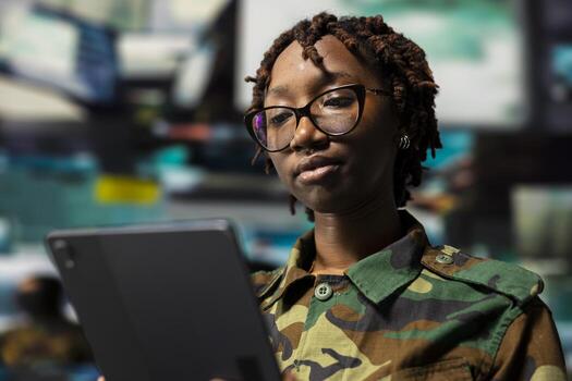 Close up of army officer using reconnaissance tech on laptop to do threat monitoring and target recognition in command post. Woman employing modern warfare intelligence using software on notebook photo