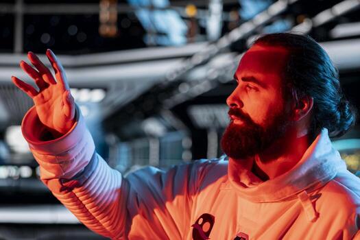 Cosmonaut reacting defensively to red light alert during space station security breach. Spaceship crew member responds to unknown danger detected during alien perimeter scan photo