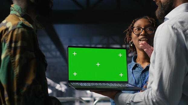 Military command center engineering team using chroma key notebook. Army IT expert and coworkers in data center using green screen laptop to defend networks against threats photo