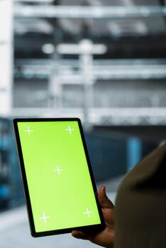 Manager in sustainable data center implements green technologies using touchscreen device. Worker uses chroma key device and energy efficient solutions to reduce server hub carbon footprint photo