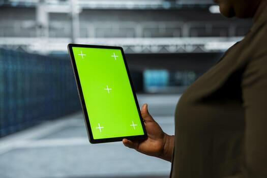 Data center technician using isolated screen tablet to automate anomaly detection. Server farm employee using chroma key device, minimizing downtime through predictive maintenance photo
