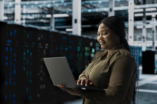 Smiling engineer does maintenance on data center electronics processing large datasets. Happy server hub IT professional does backups to protect equipment used by cloud storage hosting companies photo