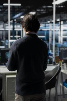 Data center system administrator deploying servers and doing maintenance on network hardware. IT professional in server room managing large scale IT infrastructure rackmounts photo