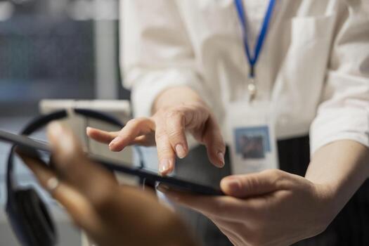 Close up of data center engineering team using tablet to inspect gear, doing maintenance tasks. Server farm coworkers using device to conduct system checks on network rigs photo