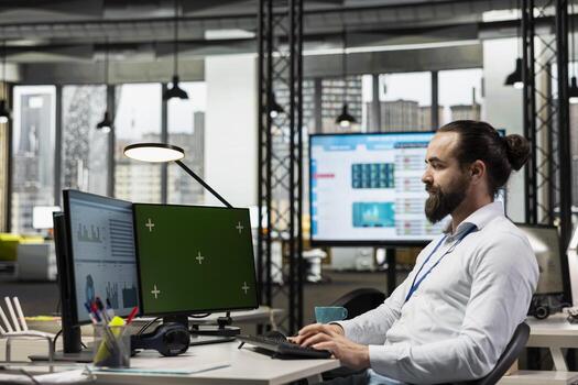 Business manager working on report writing next to chroma key screen, reviewing data analytics in the office. Specialist building a business strategy with his vision, planning progress. photo