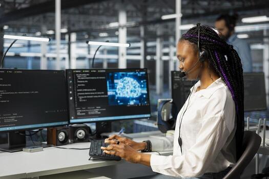 Software developer in data center speaking in headset mic, using AI to provide user tech support. IT professional in server room assisting clients during remote call using machine learning tech photo