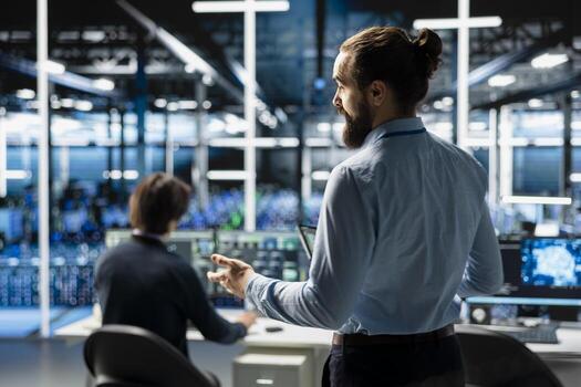 Teamworking admins coding in data center, updating AI driven automation scripts. Server room colleagues programming artificial intelligence algorithms, debugging infrastructure photo