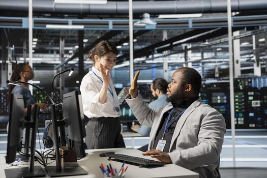 Delighted data center colleagues doing high five, celebrating successful AI implementation. Happy server hub engineering team excited after optimal results achieved by artificial intelligence model photo
