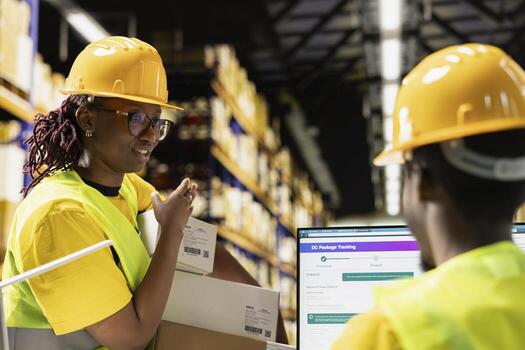 Black logistics workers team handling cargo tracking on pc software, ensuring express delivery for boxes with shipping labels. Industrial e-commerce distribution operations in action. photo