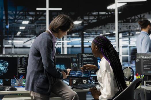 Team leader helping intern in data center to use AI LLM assistant to do maintenance on rigs. Manager and trainee doing internship in server hub, using large language model chatbot to do backups photo