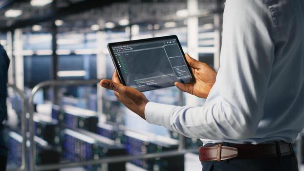 Close up of data center programmer looking at code debugging tools running on tablet. Server farm IT professional checking machine learning script automating tasks photo