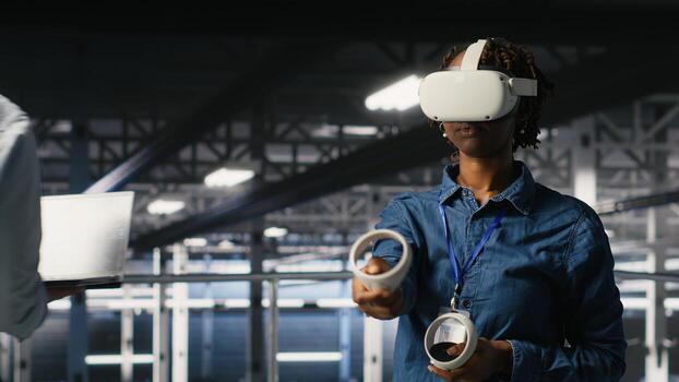 Engineer on data center industrial platform analyzing performance outputs using virtual reality tech. Server hub colleagues finetuning server rig configurations using VR headset tech photo