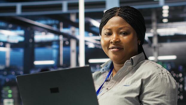 Cheerful data center employee using node tree software to analyze datasets. Upbeat server facility engineer using visual programming to improve infrastructure performance, camera B photo