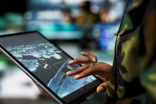 Close up of military defense security agent using device to track threats. Counterterrorism division officer in command post using target acquisition tech on tablet to detect enemy location photo