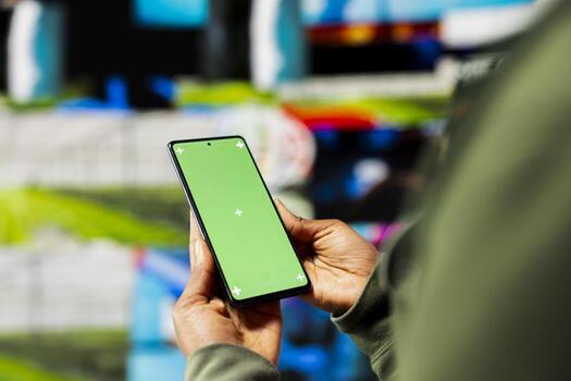 Close up of user engaging with multimedia content on green screen smartphone, showcasing power of technology and digital content. Person interacting with apps on mockup mobile phone photo