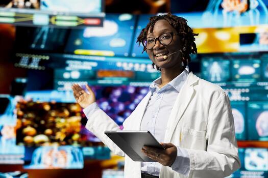 Smiling researcher doing key note presentation using holographic medical data charts, talking in mic. Jolly biomedical professional presents human organ diagnostics scans diagrams to audience at event photo