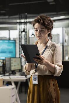 Professional workspace where focused employee developing business solutions with tablet, combines strategy planning and performance metrics analysis for new goals achievement. photo