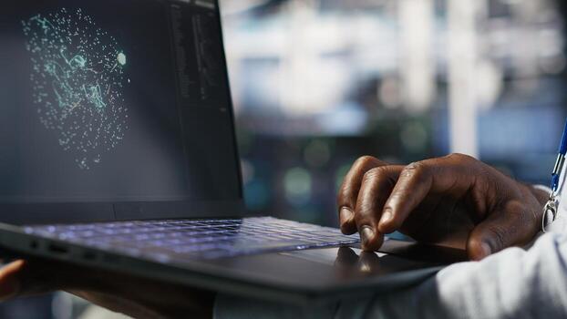 Close up of data center worker using laptop to interpret data analytics graphs. Server room technician using artificial intelligence on notebook displaying system metrics, camera B photo