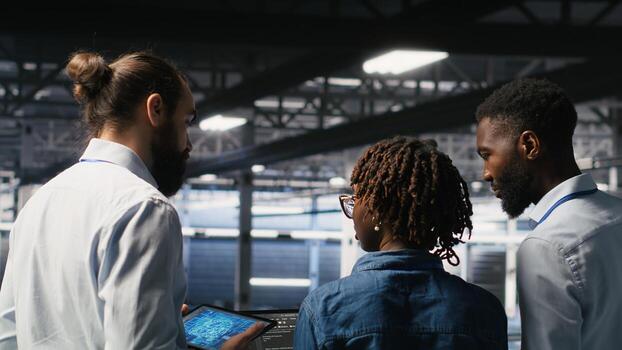 Software developers in data center monitoring AI LLM visualization. Server farm teamworking colleagues doing brainstorming, overseeing rigs powering machine learning processes photo