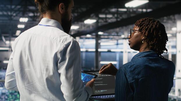 Data center system administrators performing maintenance on supercomputers used for AI. Engineering team managing server hub rigs used for deep learning training photo
