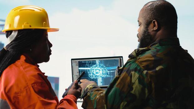 Close up of military unit and technician on offshore rig using artificial intelligence systems. Soldier provides protection to drilling barge engineering team using AI neural network systems photo