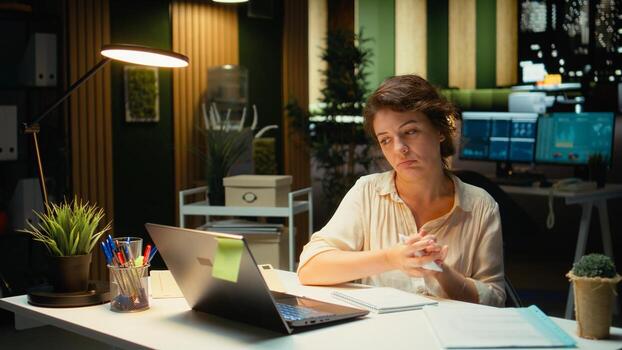 Corporate strategist ripping a paper after writing the wrong idea, restarting her work in rage and crumpling the page sheet, Discontent woman does a typo mistake while transcribing. Camera A. photo