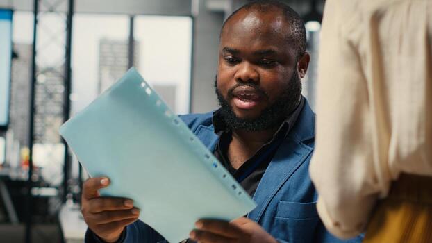 Close up of office secretary pushes a trolley filled with paperwork and documents, bringing files to a colleague and ensuring efficient distribution of resources. Workplace support. Camera B. photo