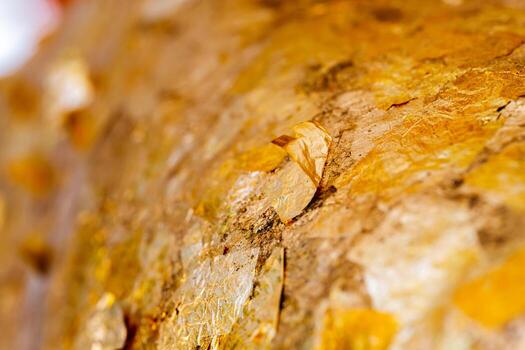 Extreme close-up of gold leaf applied to textured surface, possibly a Buddha statue or temple column. Texture and shimmer of gold. Emphasizing the texture, vibrancy, and devotional aspect of offering. photo