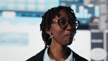 stänga upp av chef leder visionär företag kasta på händelse, som visar prestanda metrik grafer på skärm till inspirera publik. affärskvinna håller på med offentlig tala på konvent, innehav Tal video